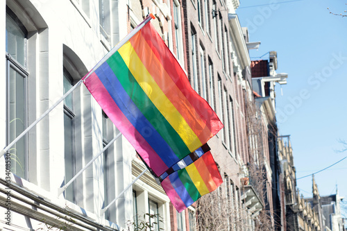 Canvas Print Rainbow LGBTQ Pride flag on the flagpole on the facade of the house