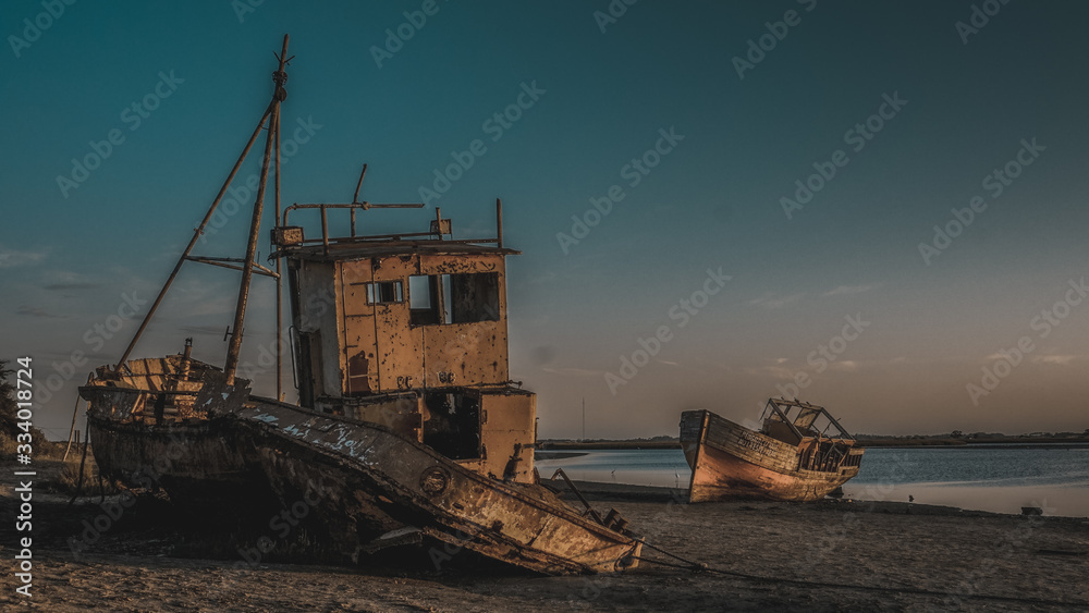 bote pesquero abandonado en laguna al costado del puerto en un atardecer en punta rasa, san clemente del tuyu provincia de buenos aires