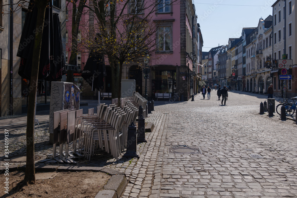 Fototapeta premium Empty street with closing shop, cafe and restaurant during quarantine from contagion of COVID-19 on walking street and plaza in old town in Düsseldorf, Germany.