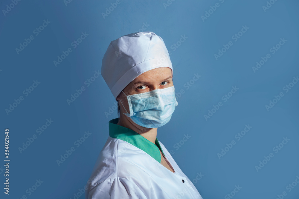doctor girl in a protective mask on a background of blue wall doctor girl in a protective mask on a background of blue wall