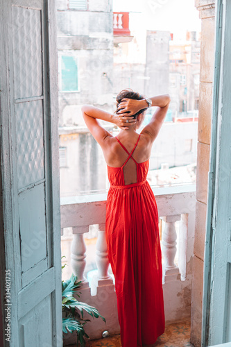 Photography Young attractive woman in red dress on old balcony in apartment in Havana