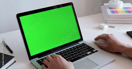 Close up shot of hand starting and ending working form home office on a laptop with green screen chroma key digital display. Man typing on a keyboard, replying on message, writing texts or chatting 