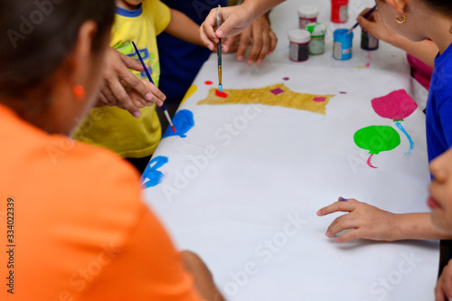 Niños con pinceles y acuarela pintando