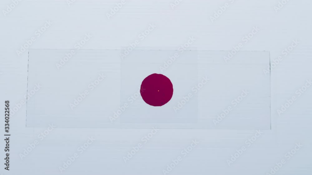 Close up top view shot of hands of lab worker in sterile gloves placing cover slip on glass slide with blood droplet while preparing for examining it under microscope