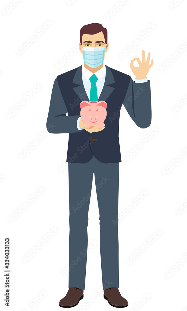 Businessman with medical mask holding a piggy bank and showing a okay hand sign. Full length portrait of Businessman in a flat style. Businessman with medical mask holding a piggy bank and showing a okay hand sign. Full length portrait of Businessman in a flat style.