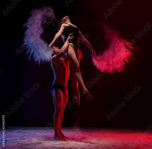 Fototapeta Naklejka Na Ścianę i Meble -  Young couple dancing in color dust shot
