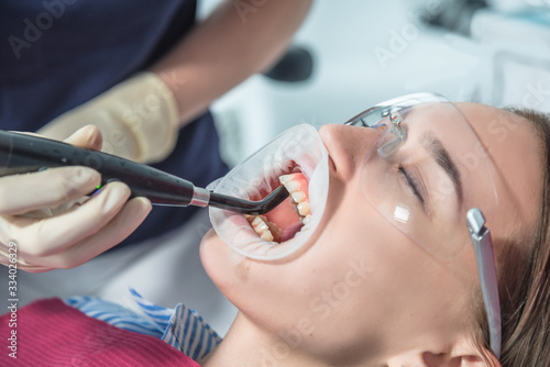 A dentist examines a patient  close-up of a patient with an open mouth next to which dental objects. The concept of health care and treatment in medical facilities