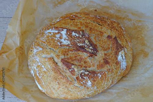Loaf of crusty miracle overnight no knead bread baked on parchment paper