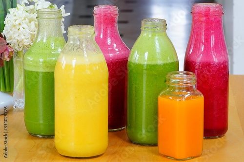 Glass bottles filled with colorful homemade fruit juice and smoothies