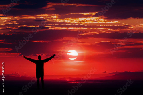 Silhouette of man on top of mountain under the sunset