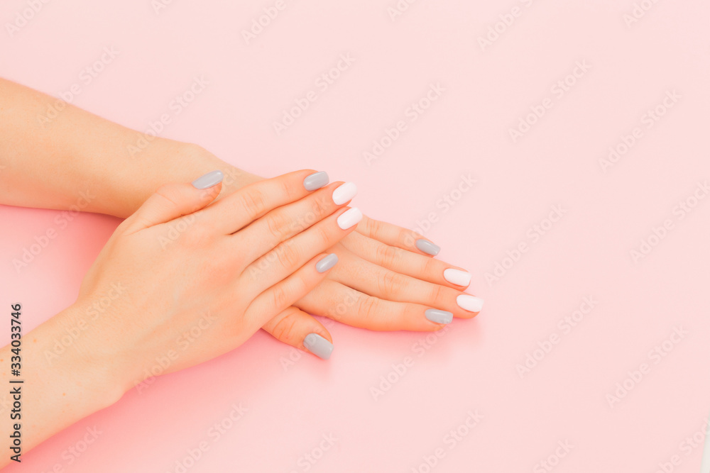 Fototapeta Stylish trendy female manicure. Beautiful young woman's hands on pink background.