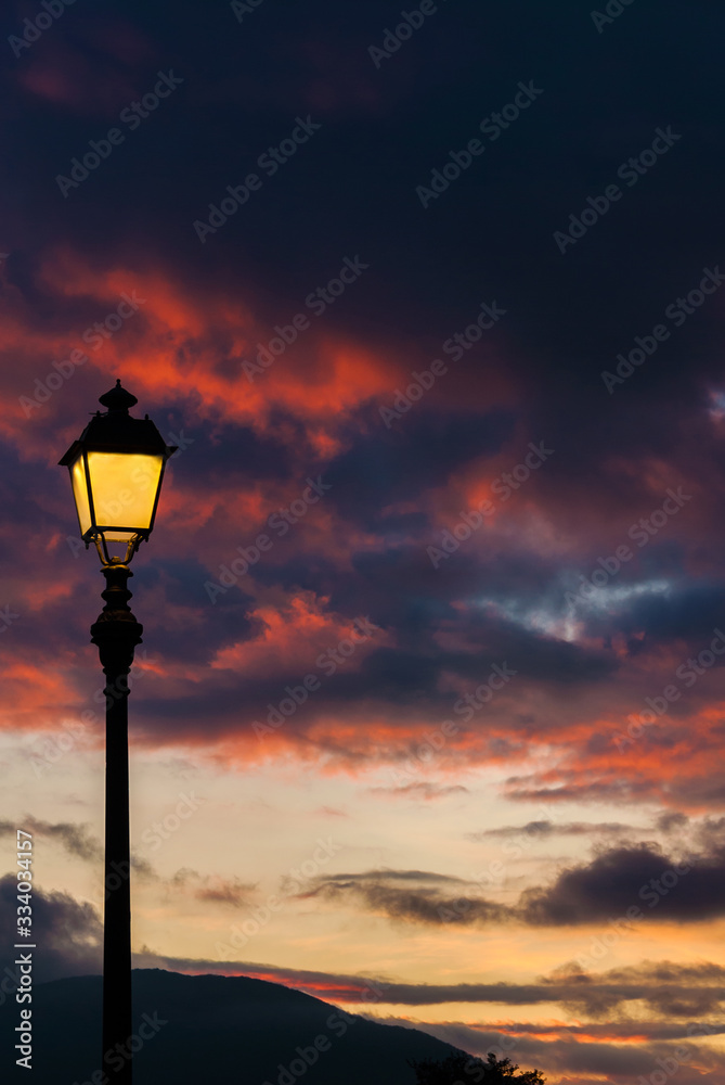 Old fashioned street lamp against sunset sky clouds (with copy space) Old fashioned street lamp against sunset sky clouds (with copy space)