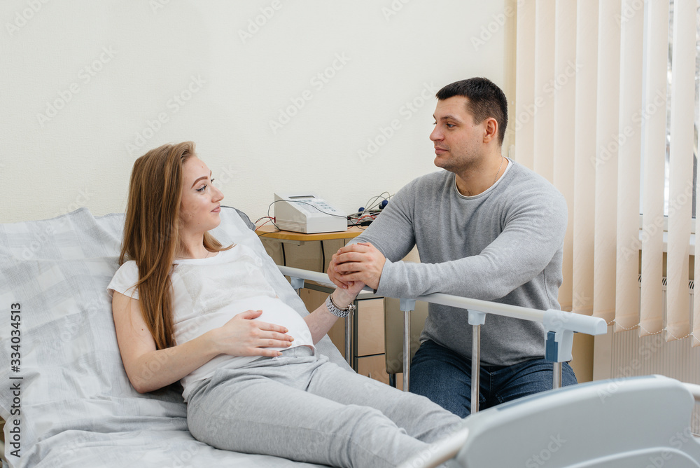 Fototapeta premium Pregnant girl in the clinic for consultation with the future father. Medical examination