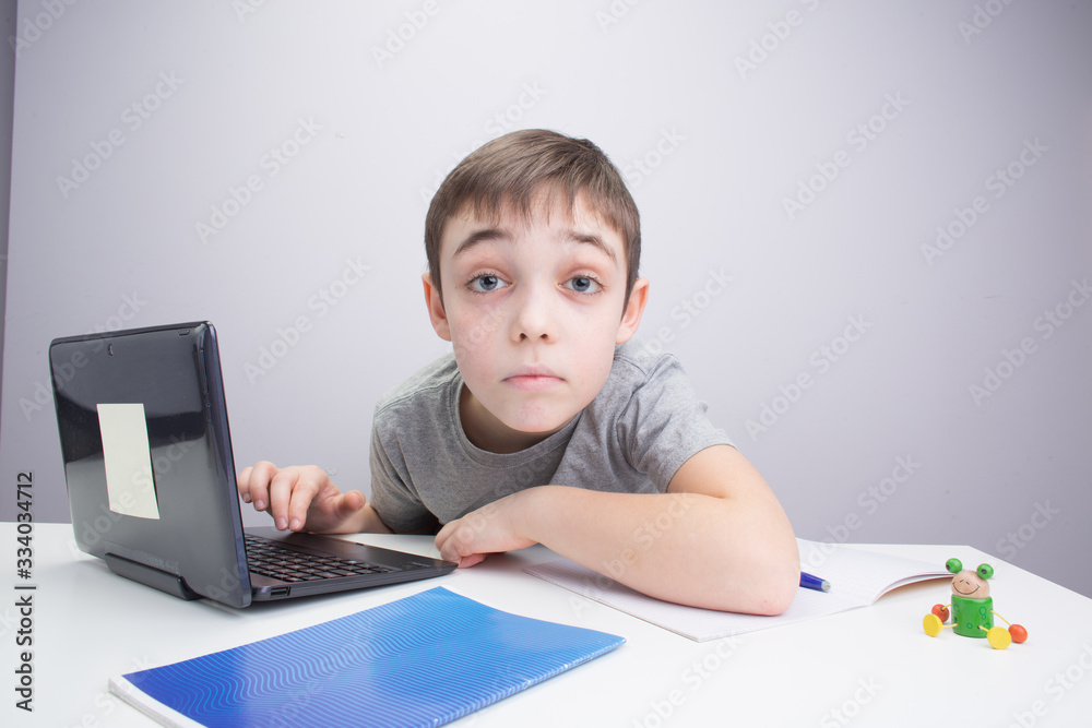 schoolboy studying homework math during his online lesson at home, social distance during quarantine, self-isolation, online education concept schoolboy studying homework math during his online lesson at home, social distance during quarantine, self-isolation, online education concept