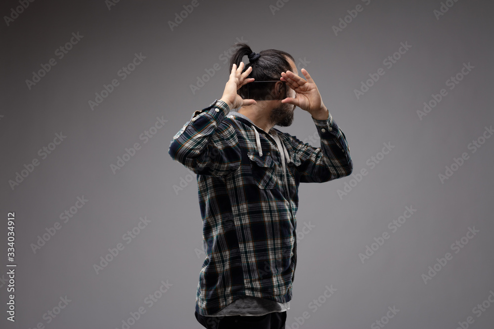 Man turned away, holding phone behind his head Man turned away, holding phone behind his head