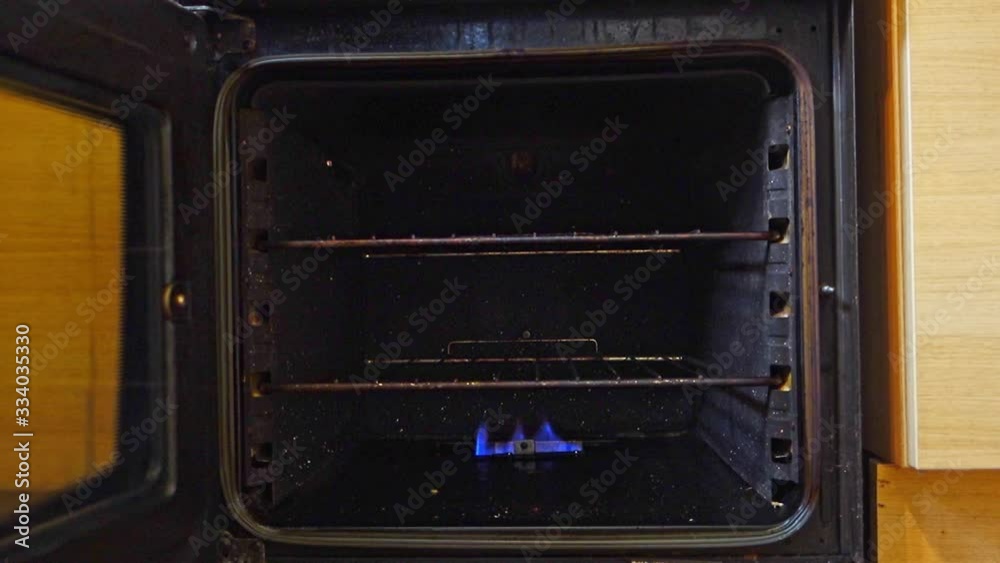 Putting cake tins into a gas oven to bake Putting cake tins into a gas oven to bake