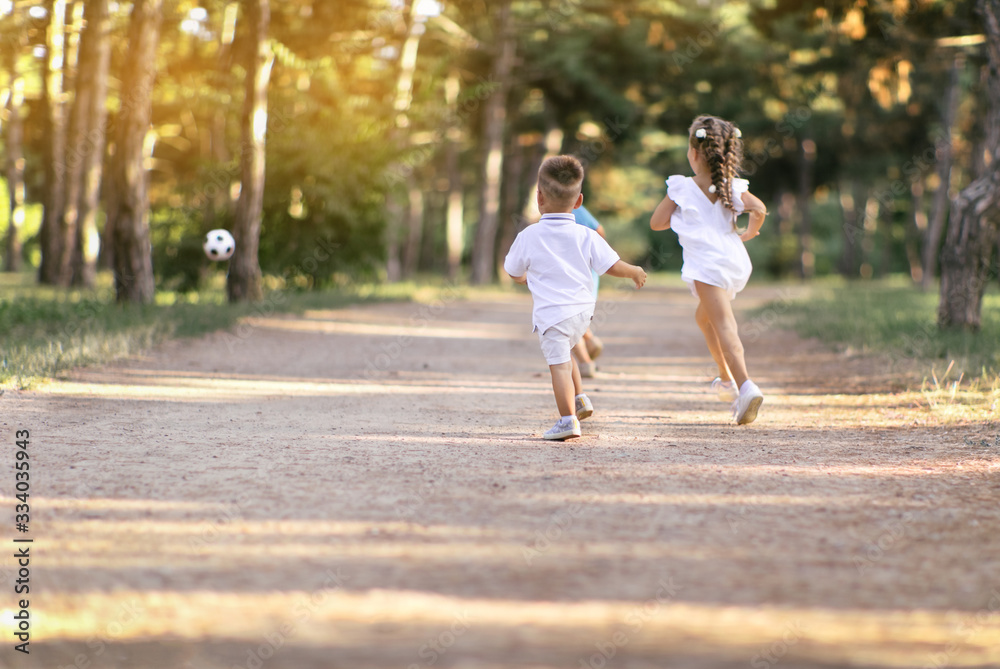 Fototapeta premium Children run along the road during sunset