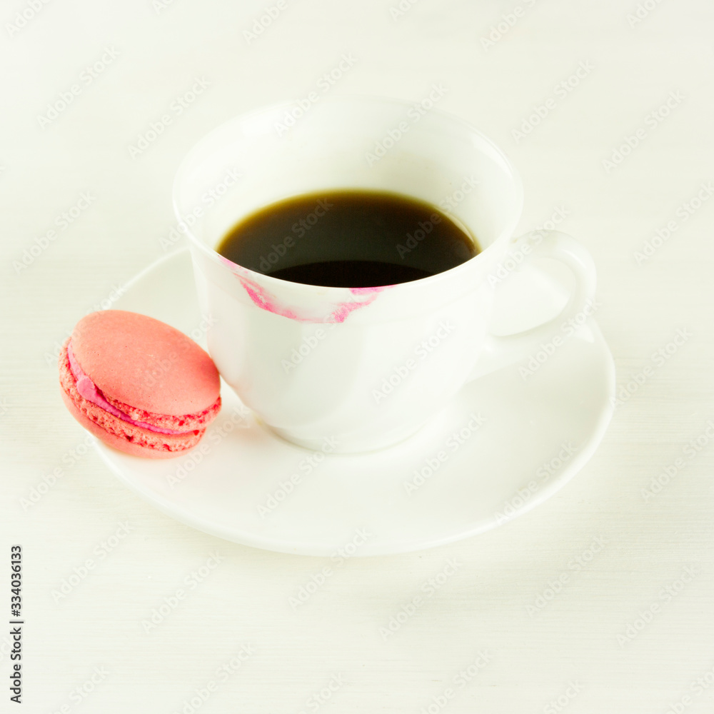 cup of strong black coffee with pink macaroons and traces of lipstick on a white background, coffee with love. romantic morning concept cup of strong black coffee with pink macaroons and traces of lipstick on a white background, coffee with love. romantic morning concept