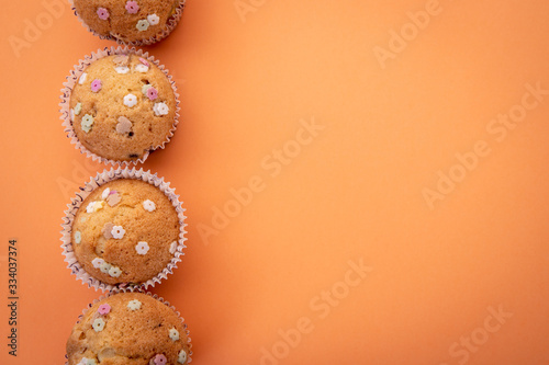 Muffinki z kolorową posypką na kolorowym tle