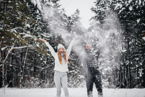 Fototapeta Naklejka Na Ścianę i Meble -  Couple playing with snow in the forest