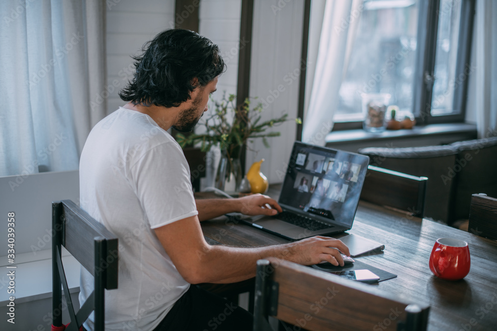 Workplace at home. A man works at a laptop at home Workplace at home. A man works at a laptop at home