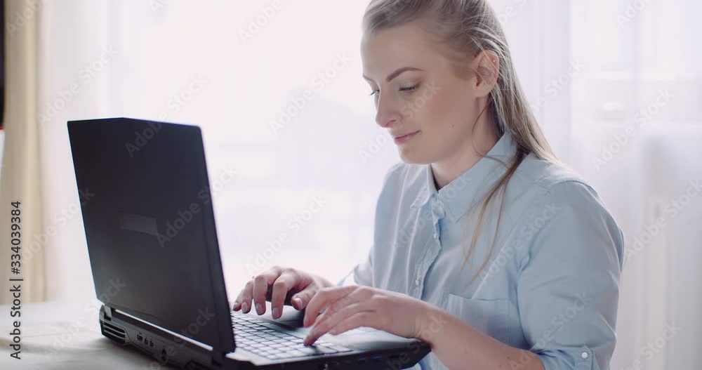 Smiling Woman Working on Laptop at Home Office. Businesswoman Typing on Computer Keyboard. Smiling Woman Working on Laptop at Home Office. Businesswoman Typing on Computer Keyboard.