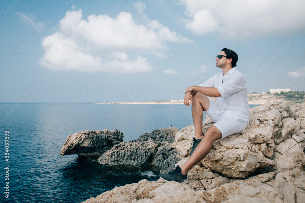 A man on the rocks overlooking the sea A man on the rocks overlooking the sea