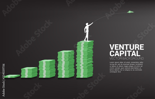silhouette of businessman throw out money banknote origami paper airplane from banknote stack graph. Business Concept of start business and entrepreneur