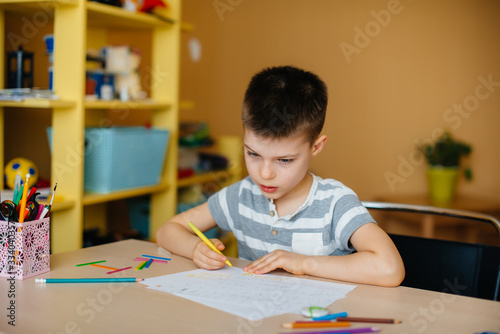 A school-age boy does homework at home. Training at school