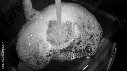 Water running from a tap into a sink. Close-up shot photo