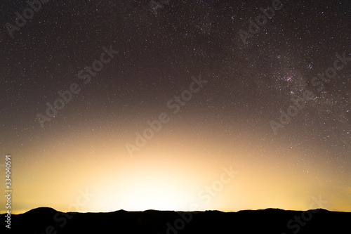 Panorama photo of the Milky Way over the Blue Mountains, illuminated by the light pollution of Sydney