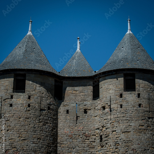 Picturesque walls of medieval  castle with metal roofs observing towers.