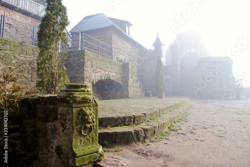 LANDSTUHL, GERMANY - 2014: Burg Nanstein (Nanstein Castle) in Landstuhl, Germany on a foggy, misty morning. It was built around 1162. Castle entrance with moss coves carved lion.  photo