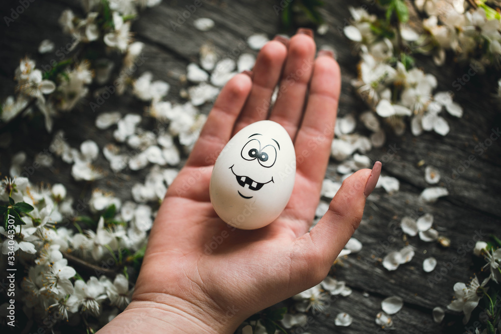 Egg on wooden background in human hands. Easter. Eggs. Bunny. Painted eggs. Holy day. People. Religion. Egg on wooden background in human hands. Easter. Eggs. Bunny. Painted eggs. Holy day. People. Religion.