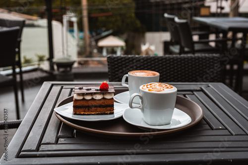 Slice of chocolate cake, Cutlery steak basket and donot with coffee on the table. photo