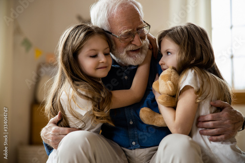 Foto Mirthful children hugging their grandpa stock photo