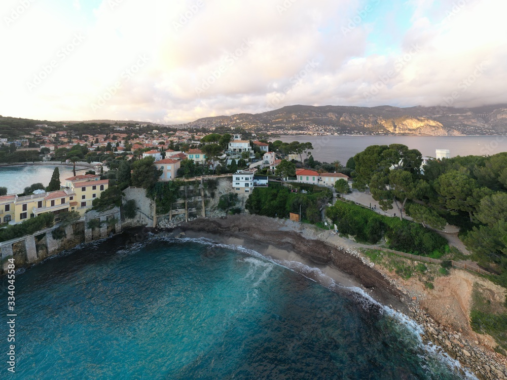 France, Saint-Jean-Cape-Ferrat, 15 December 2019: Aerial view of most expensive place in French Riviera at sunset, terraces of country houses and estates, pools, Chaise lounges, pink clouds