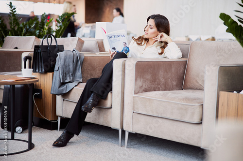 Bilde på lerret Beautiful young woman reading book in departure lounge