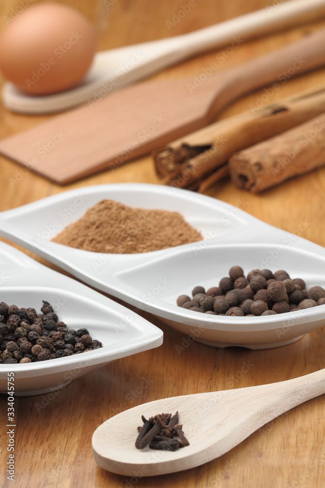 spices in spoons on wooden background spices in spoons on wooden background