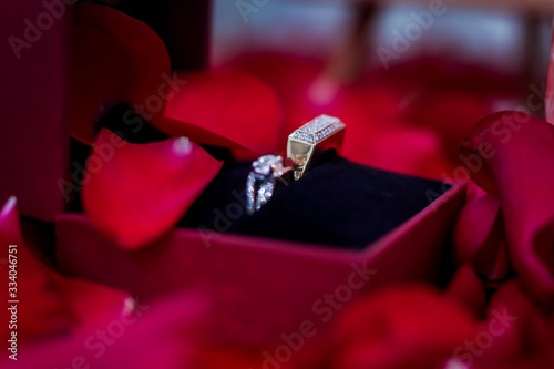 Beautiful wedding rings close up, red rose petals and candles, romantic  © Stella Kou