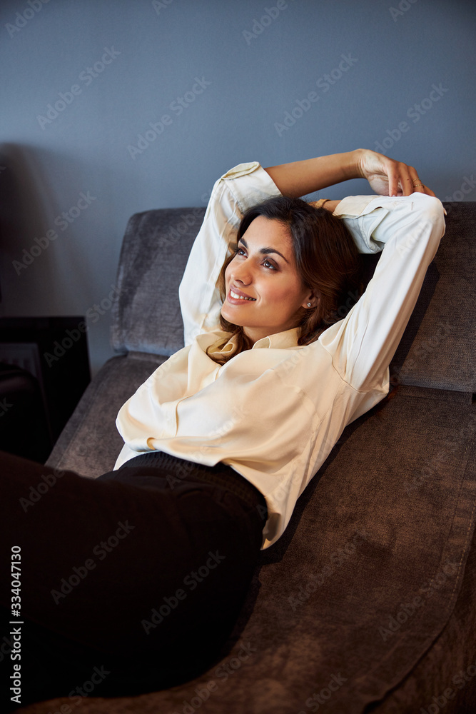 Fototapeta premium Attractive young woman resting on comfortable chair