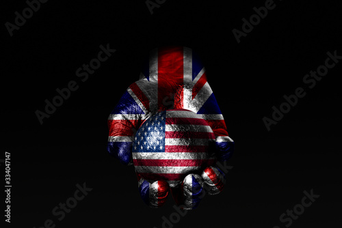 A hand with a drawn Great Britain flag holds a ball with a drawn USA flag, a sign of influence, pressure or conservation and protection.