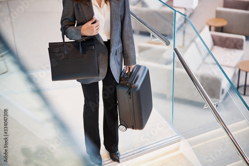 Lady with luggage standing on top of stairs in departure lounge