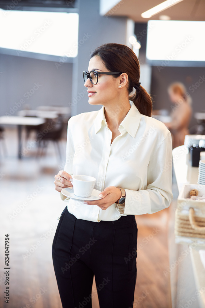 Fototapeta premium Attractive young woman holding cup of coffee