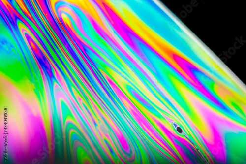 Fototapeta Naklejka Na Ścianę i Meble -  Macro of a soap bubble with rainbow colors forming abstract patterns.