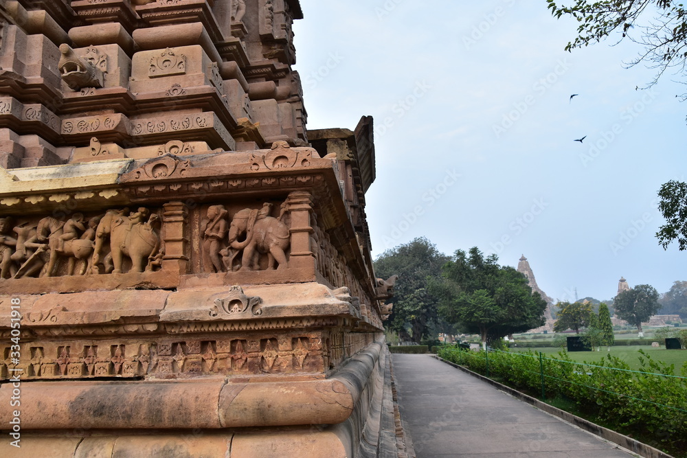 インドのカジュラーホー 世界遺産のカジュラーホー寺院 ヒンドゥー教の物語を表した繊細な彫刻 象と人間との行列の彫刻 StockFoto