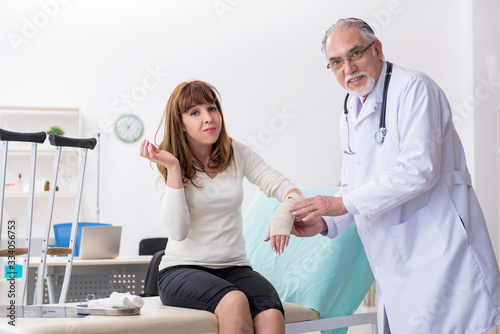 Young injured woman visiting experienced doctor traumatologist