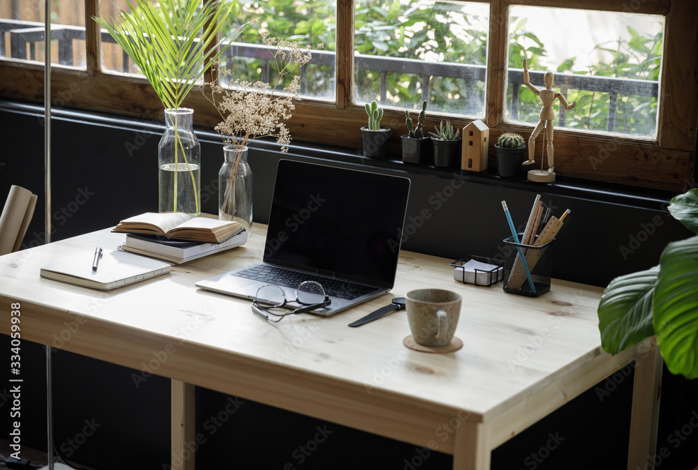 Fototapeta premium Modern home office creative space perfect for working from home lifestyle with laptop on the desk and sofa in the living room, Quarantine isolation during the Coronavirus (COVID-19) health crisis