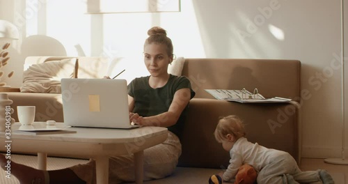 Caucasian mother working from home, having a work video call, daughter playing nearby. Stay home, quarantine remote work. Shot on RED Dragon photo