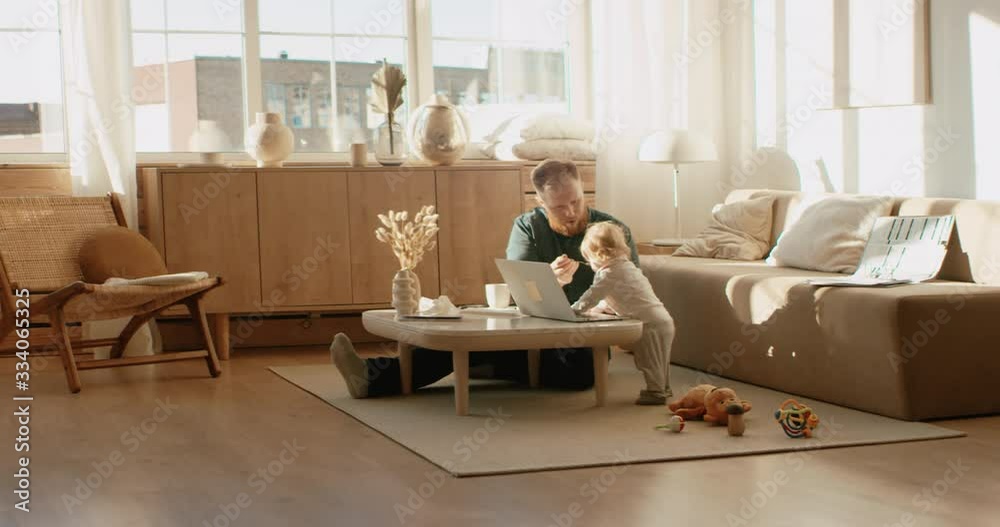 Father working from home, having a work phone call, while feeding his daughter. Stay home, quarantine remote work. Shot on RED Dragon Father working from home, having a work phone call, while feeding his daughter. Stay home, quarantine remote work. Shot on RED Dragon